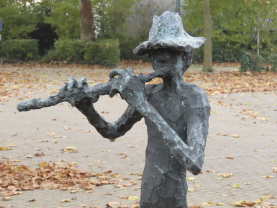 902000 Afbeelding van het bronzen beeldhouwwerk 'Fluitspeler' van Jits Bakker, bij de parkeerplaats van de Eneco ...